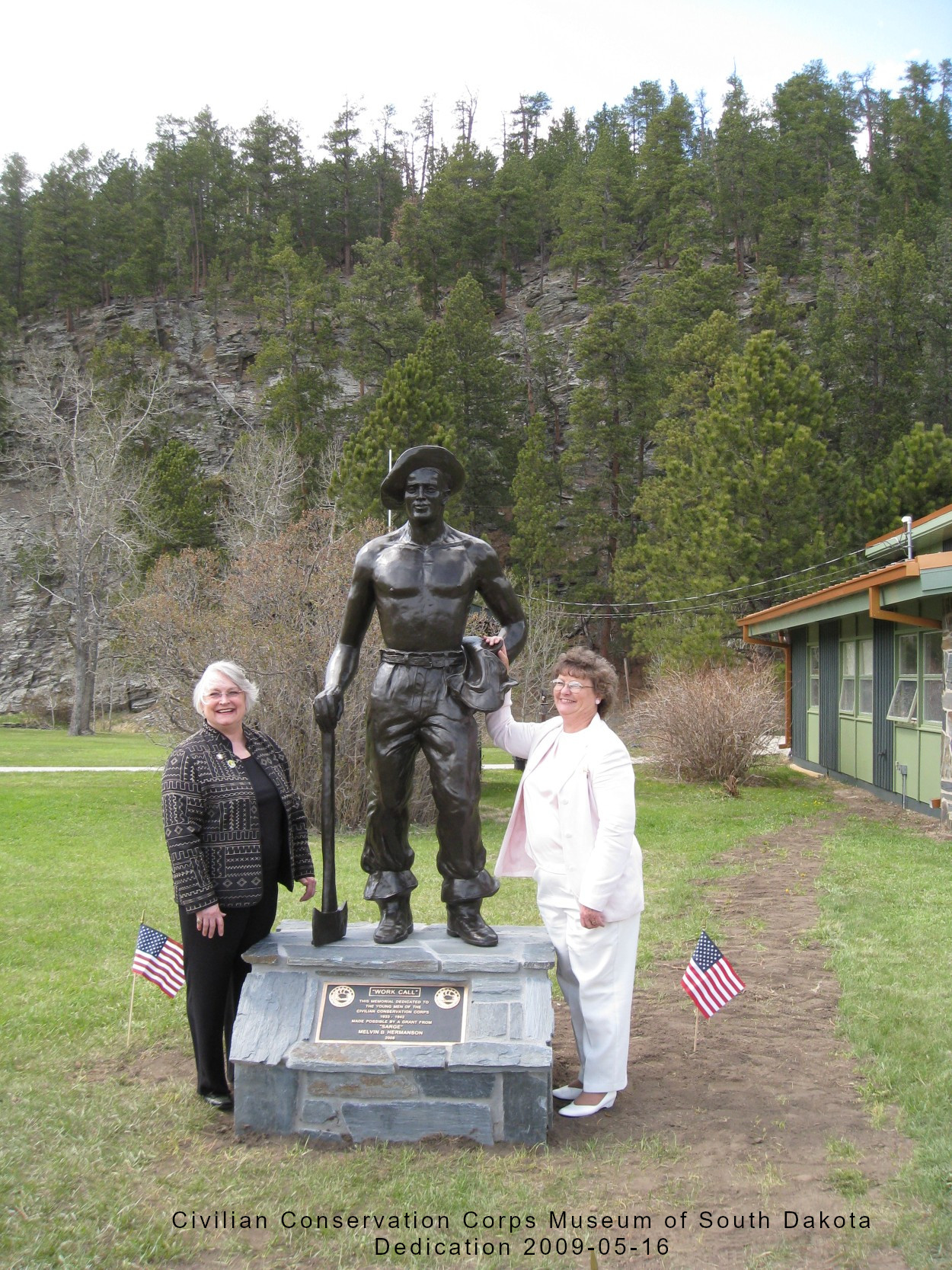 Ladies pose by statue